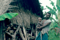 Baining man, proud of his son and his house, New Britain, Papua New Guinea. 
